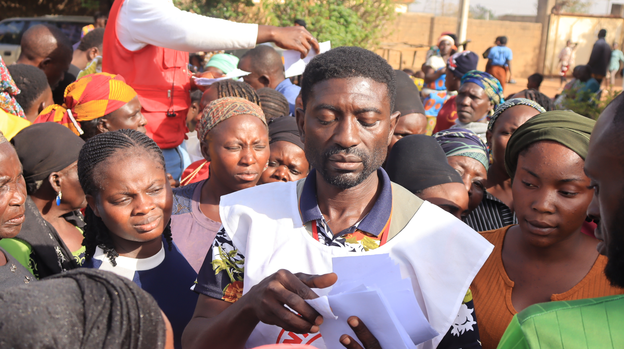 Beneficiaries jostle for position as volunteer calmly sorts out official records in order to decide  which beneficiaries will get aid-Photo Credit-Chima Nwankwo