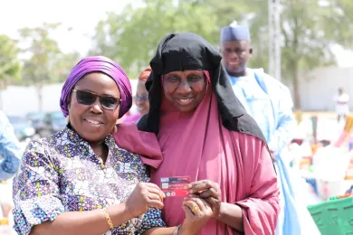 Dr Sintiki Tarfa-Ugbe, Director ECOWAS Commission, hands relief items to a beneficiary